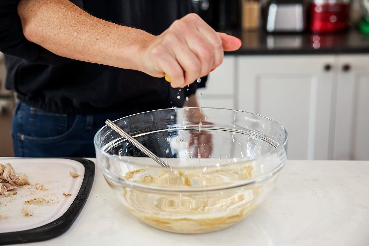 squeezing lemon into curry chicken salad