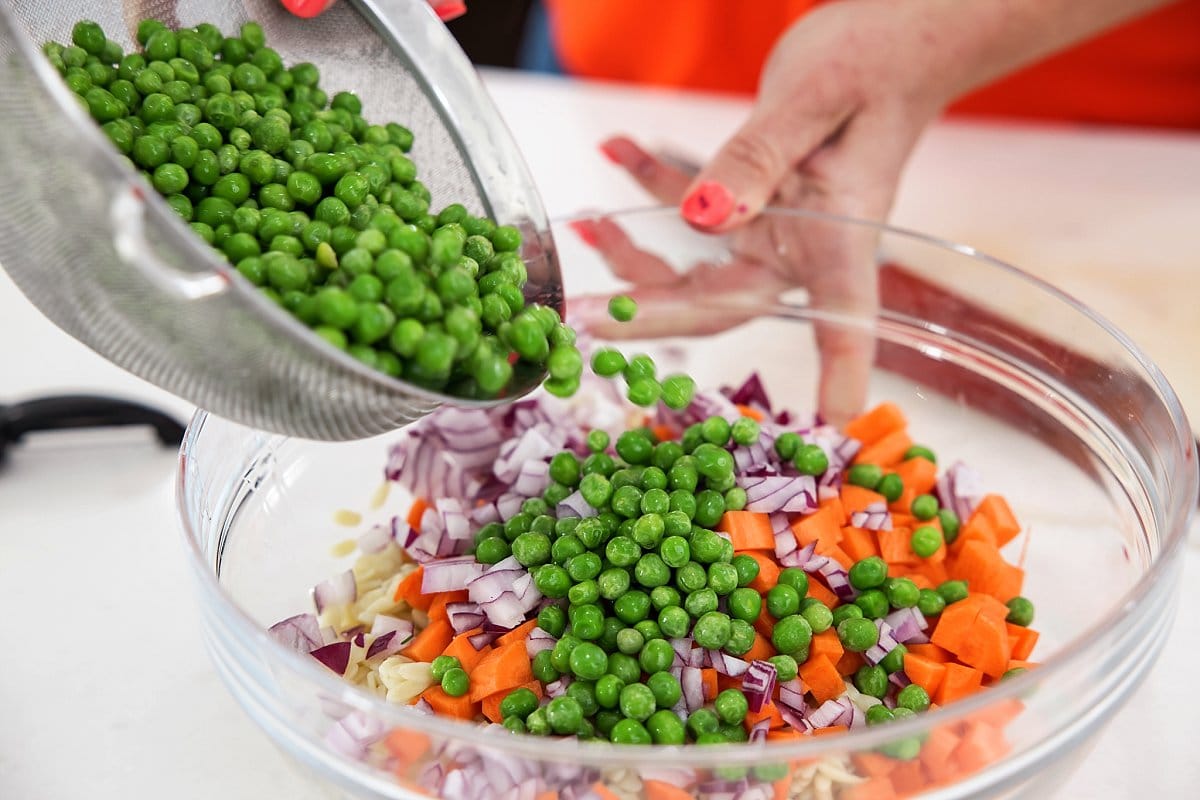 adding peas to the dill orzo salad