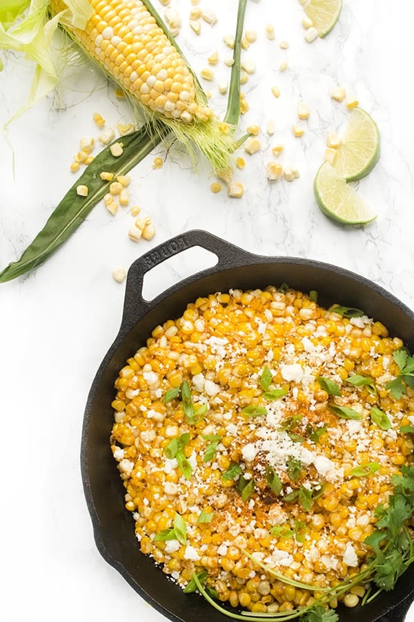 corn topped with Mexican cheese in a skillet