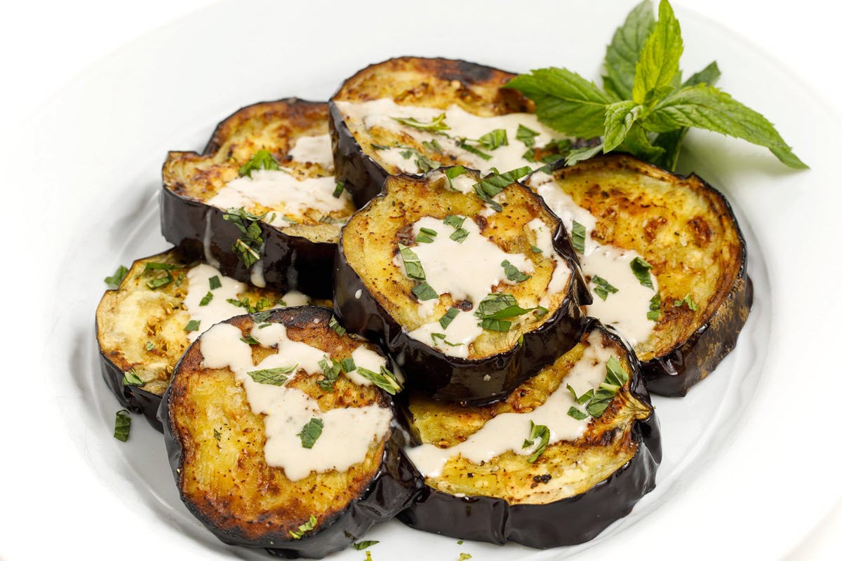 grilled eggplant with tahini sauce on a plate