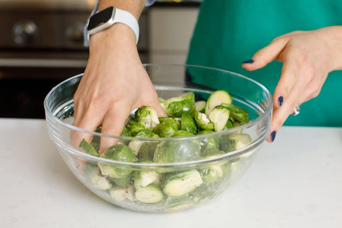woman mixing Brussels sprouts and seasonings