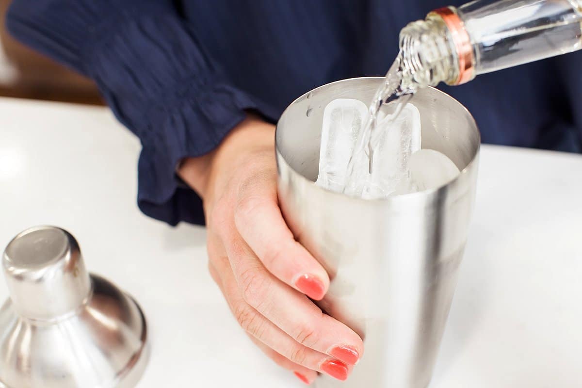 Pouring alcohol into cocktail shaker.