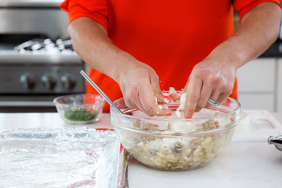 breaking up the cojita cheese into a bowl