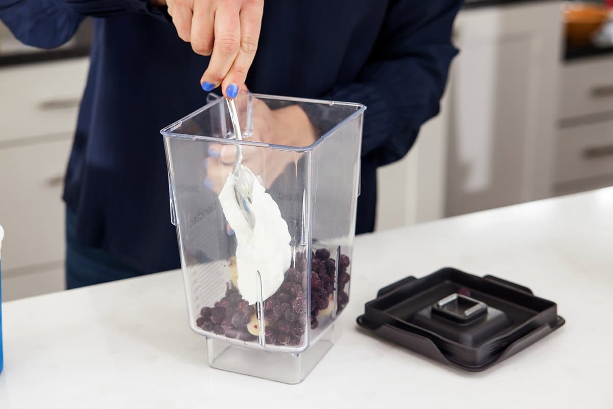adding yogurt into a blender