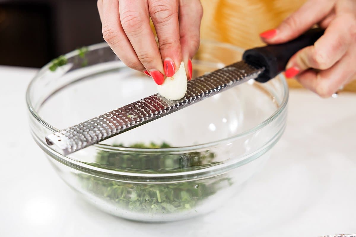 grating garlic into a bowl
