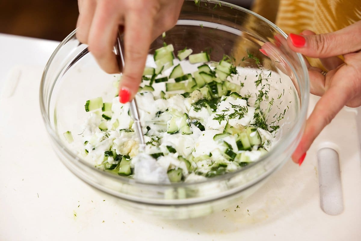 mixing tzatziki sauce in a bowl