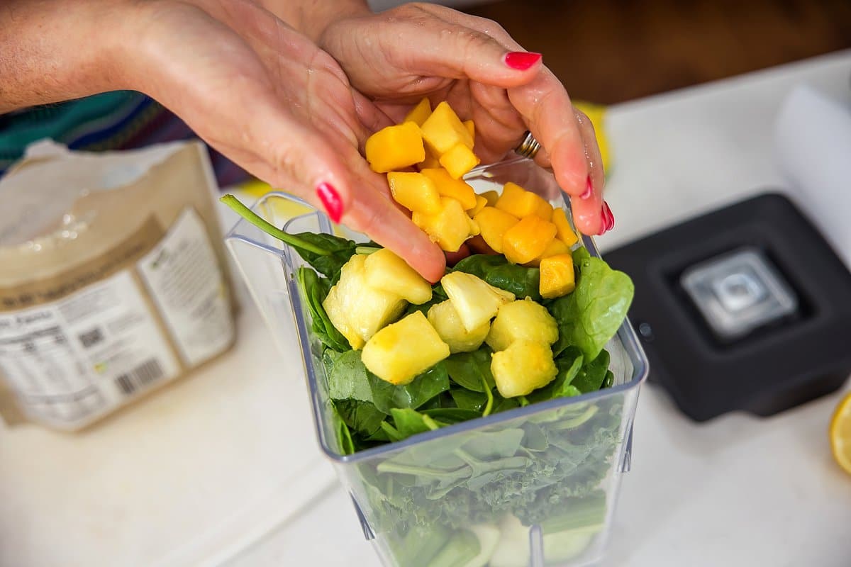 Adding pineapple and mango to blender
