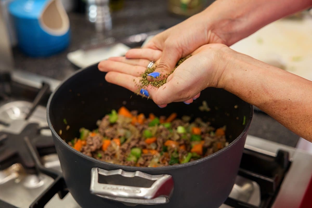 Adding spices to lamb veggie soup