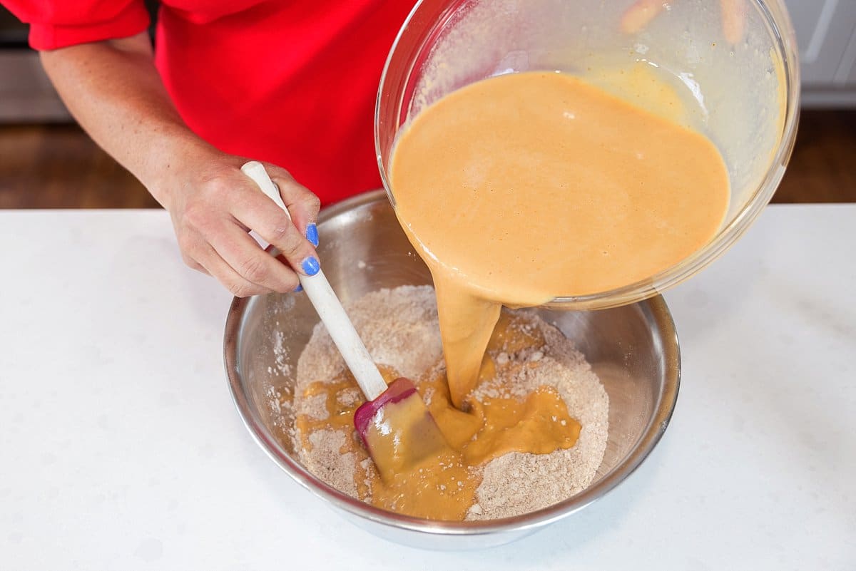 person adding wet ingredients to dry
