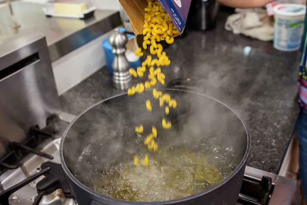pasta entering boiling pot of water