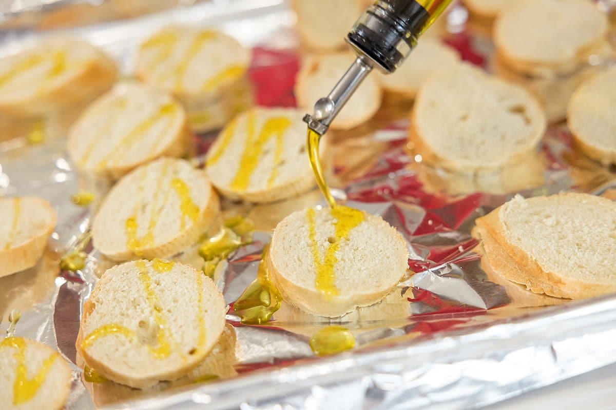 drizzling olive oil on baguette