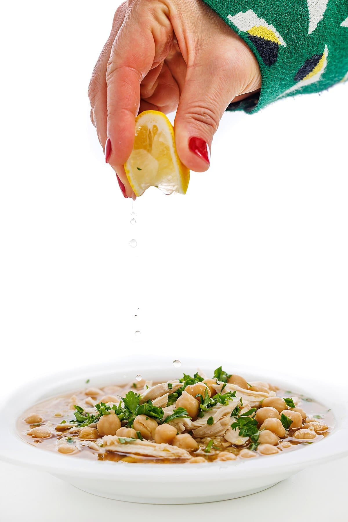 Garnishing chicken and chickpea soup with bulgur wheat.