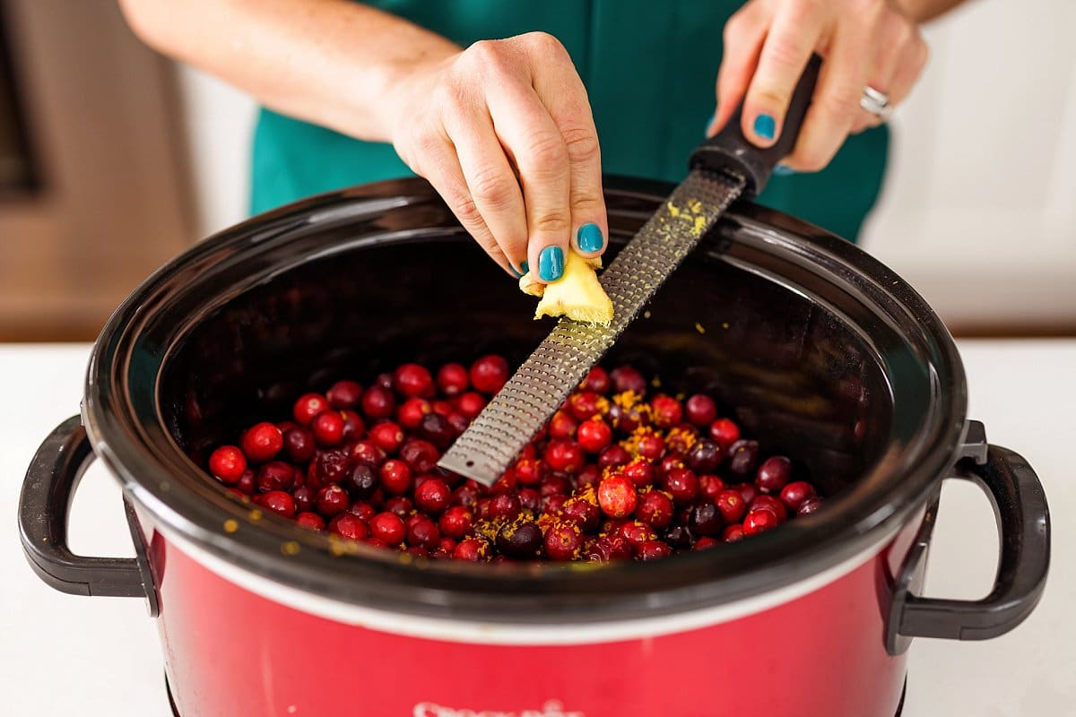 Cranberries with ginger being grated in