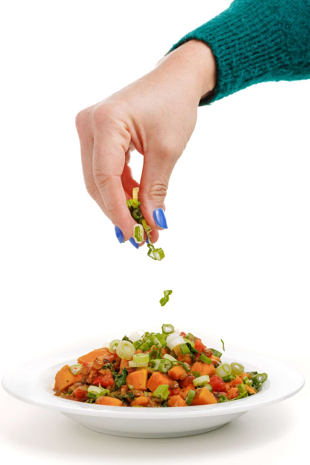 Garnishing curried lentils with sweet potatoes.