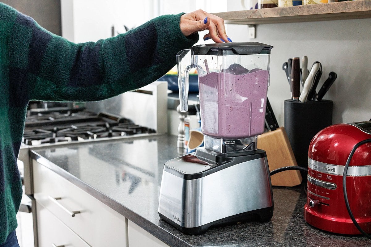 Blending blueberry banana oatmeal smoothie.