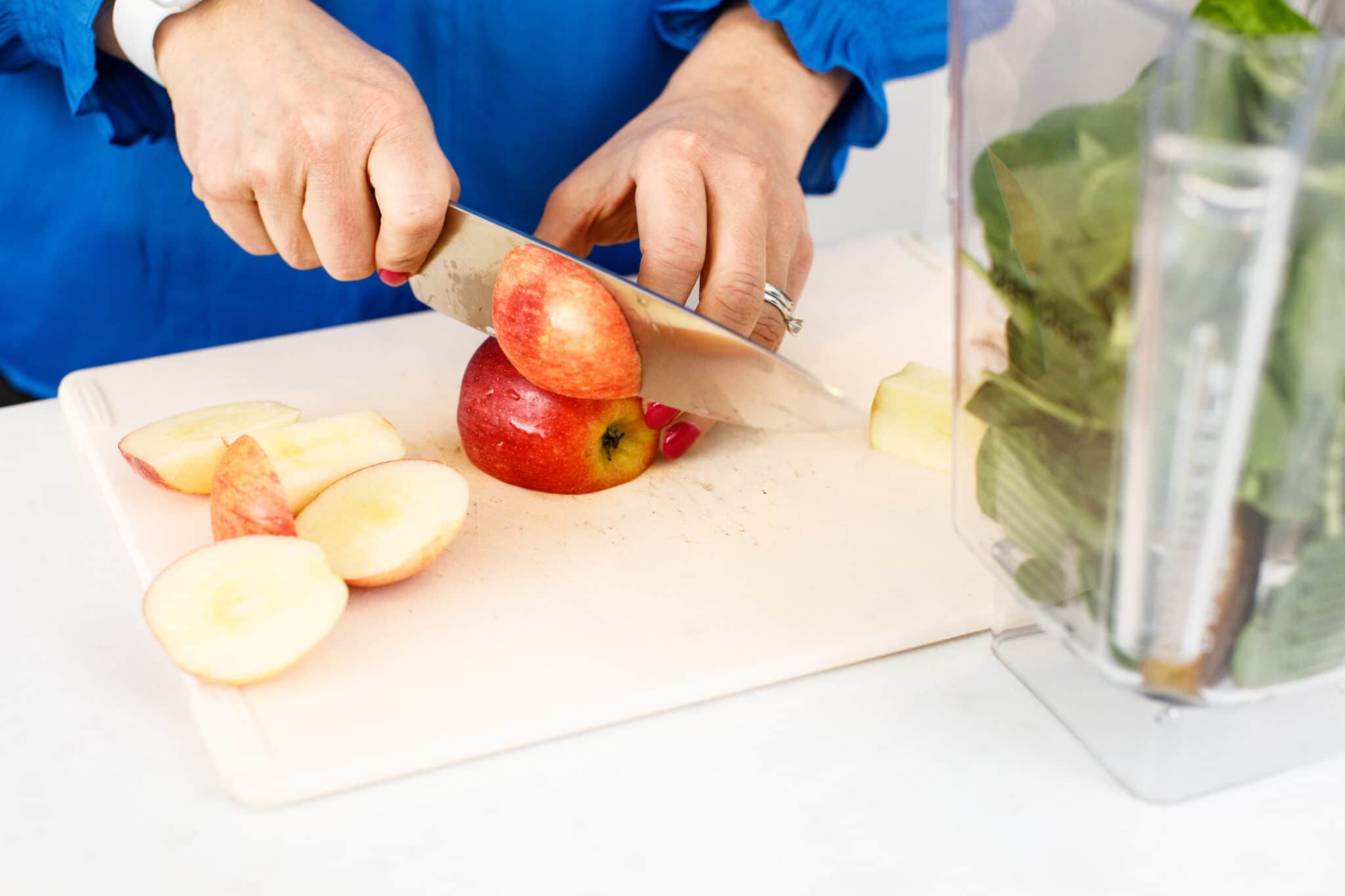 Liz cutting an apple with a sharp knife.