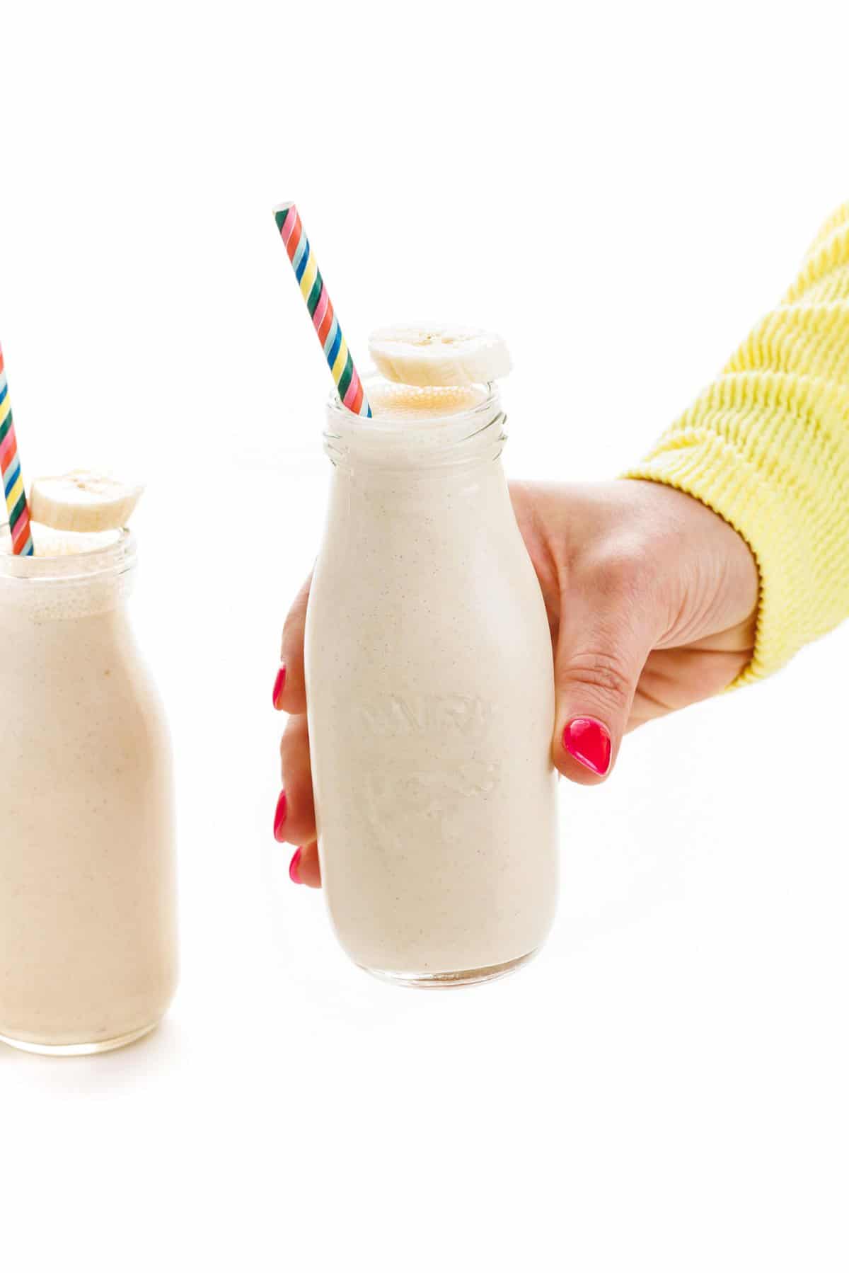 Holding a peanut butter banana oatmeal smoothie.