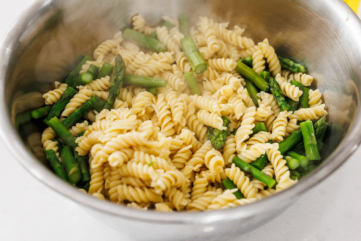 Cooked pasta and asparagus in a bowl.