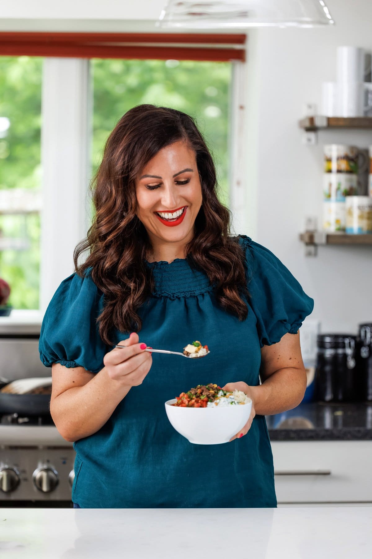 Liz eating Lebanese beef and rice bowls with hummus.