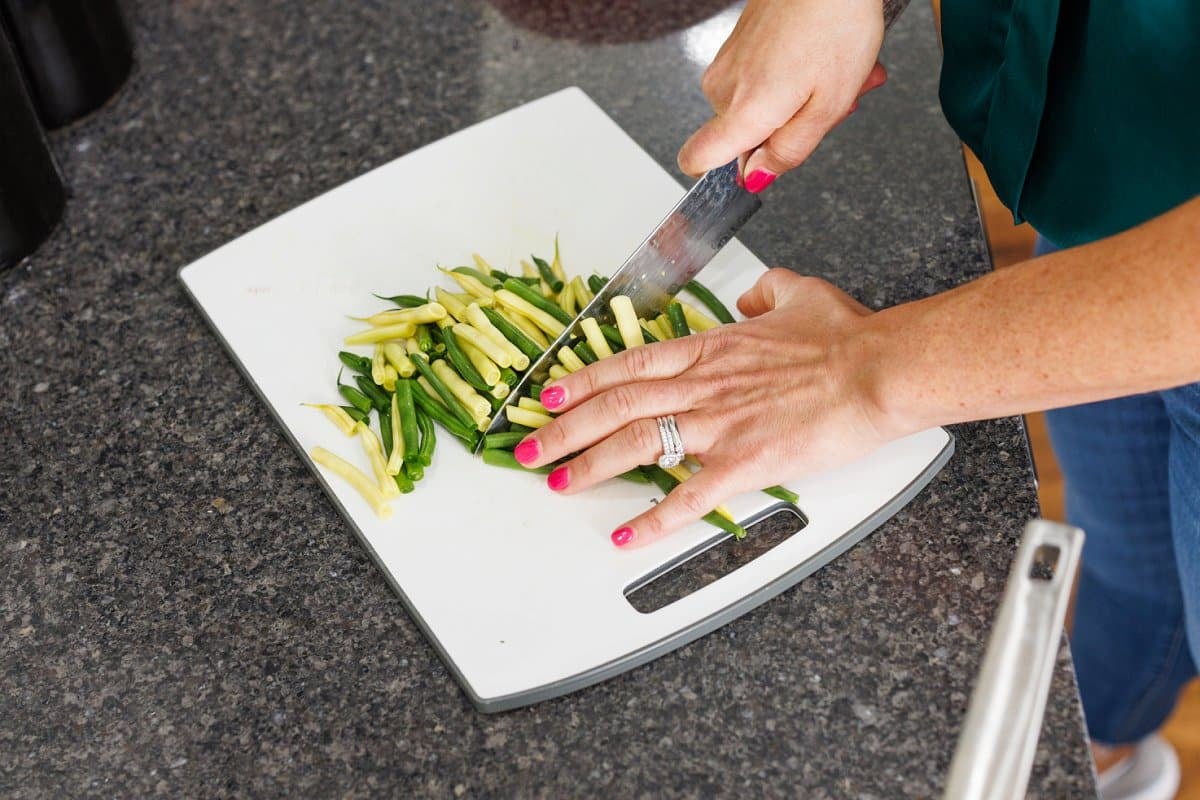 Liz using a sharp knife to cut green beans.