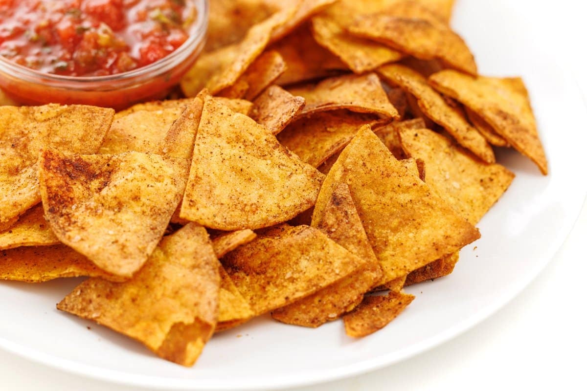 Baked corn tortilla chips served along salsa.