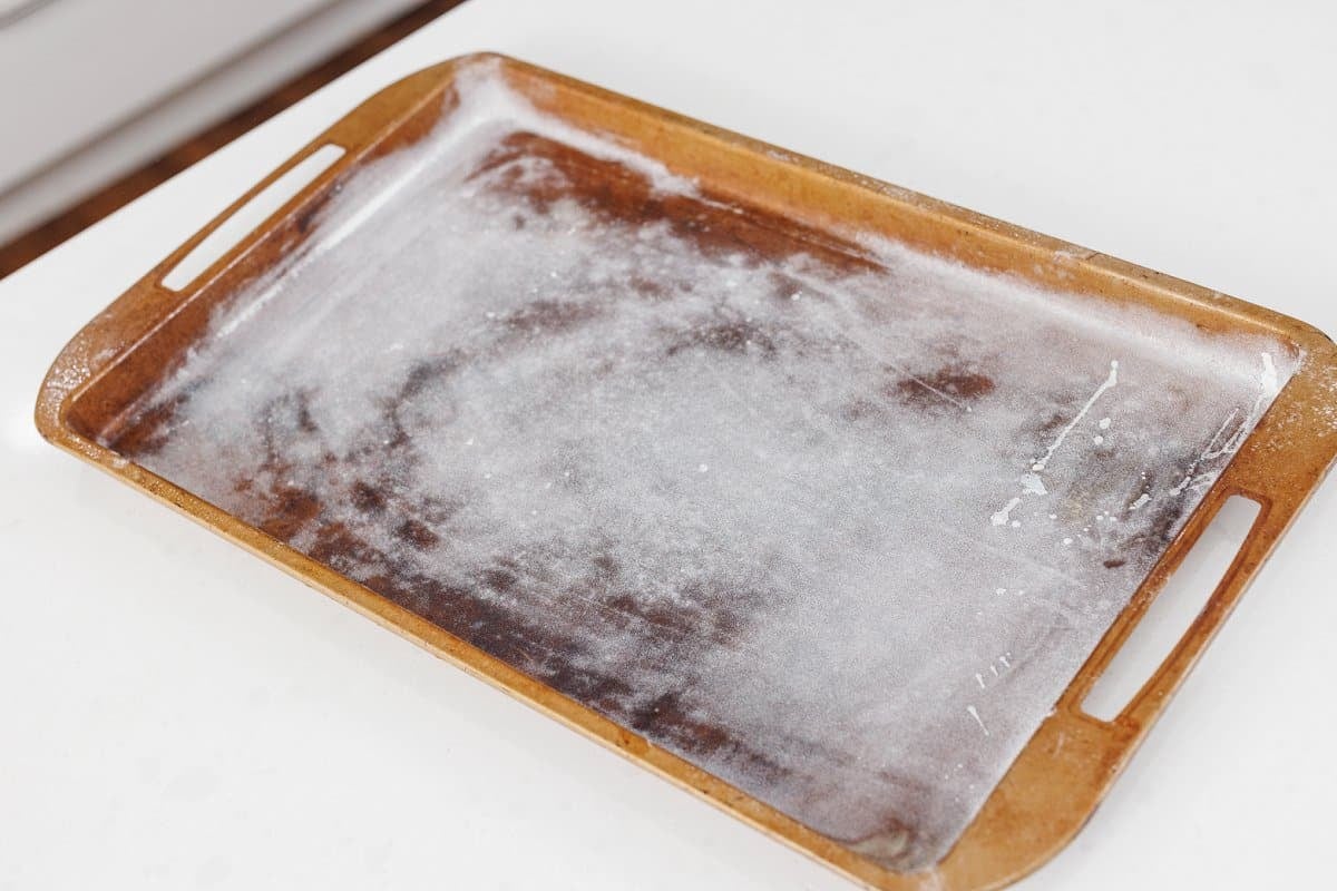 A greased and floured jelly roll pan on a counter.