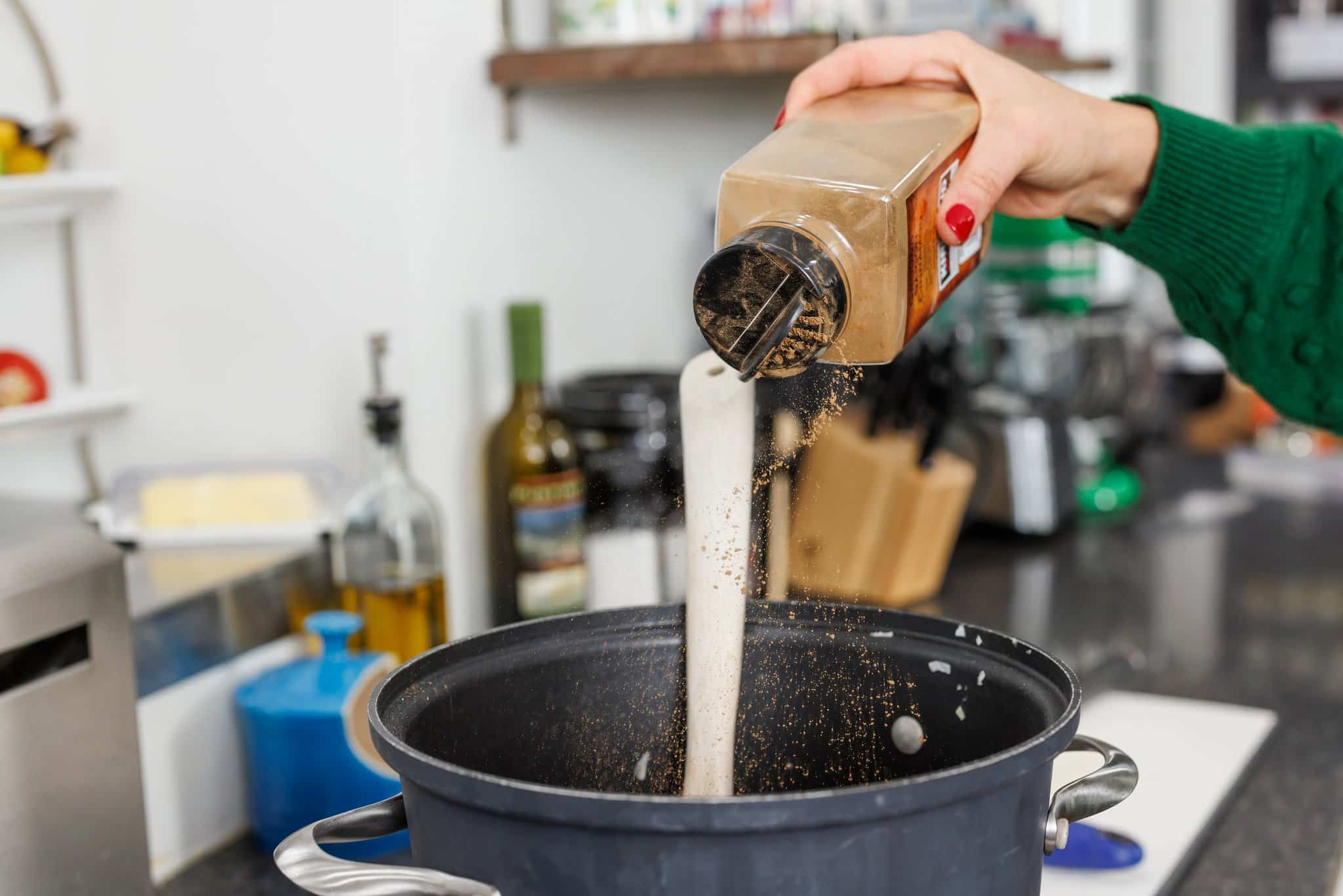 Sprinkling cinnamon into pot.