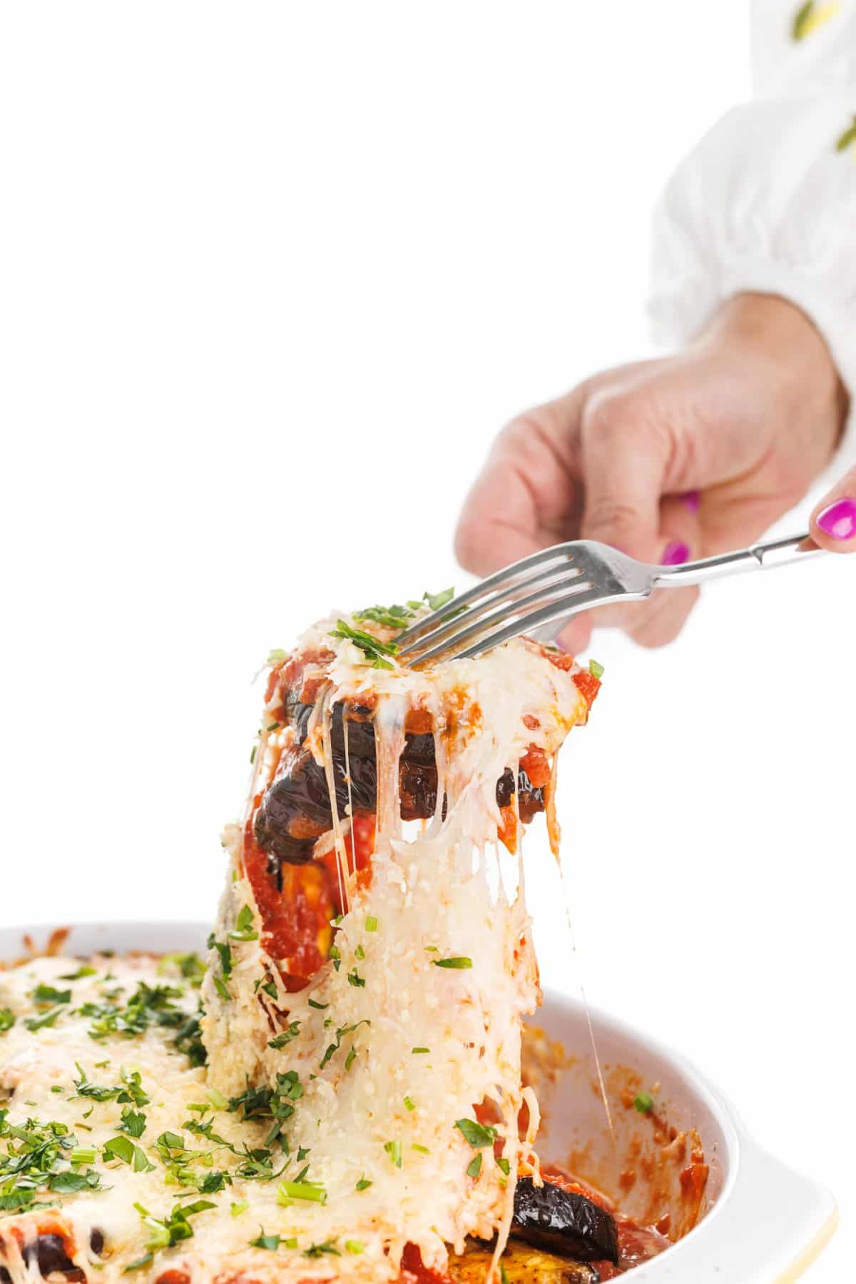 Serving grilled eggplant parmesan with two forks.