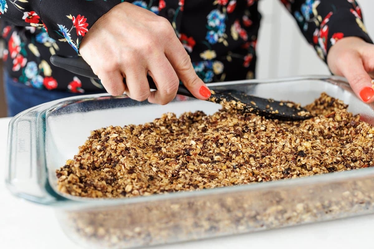 Spreading granola bar mixture into baking dish.
