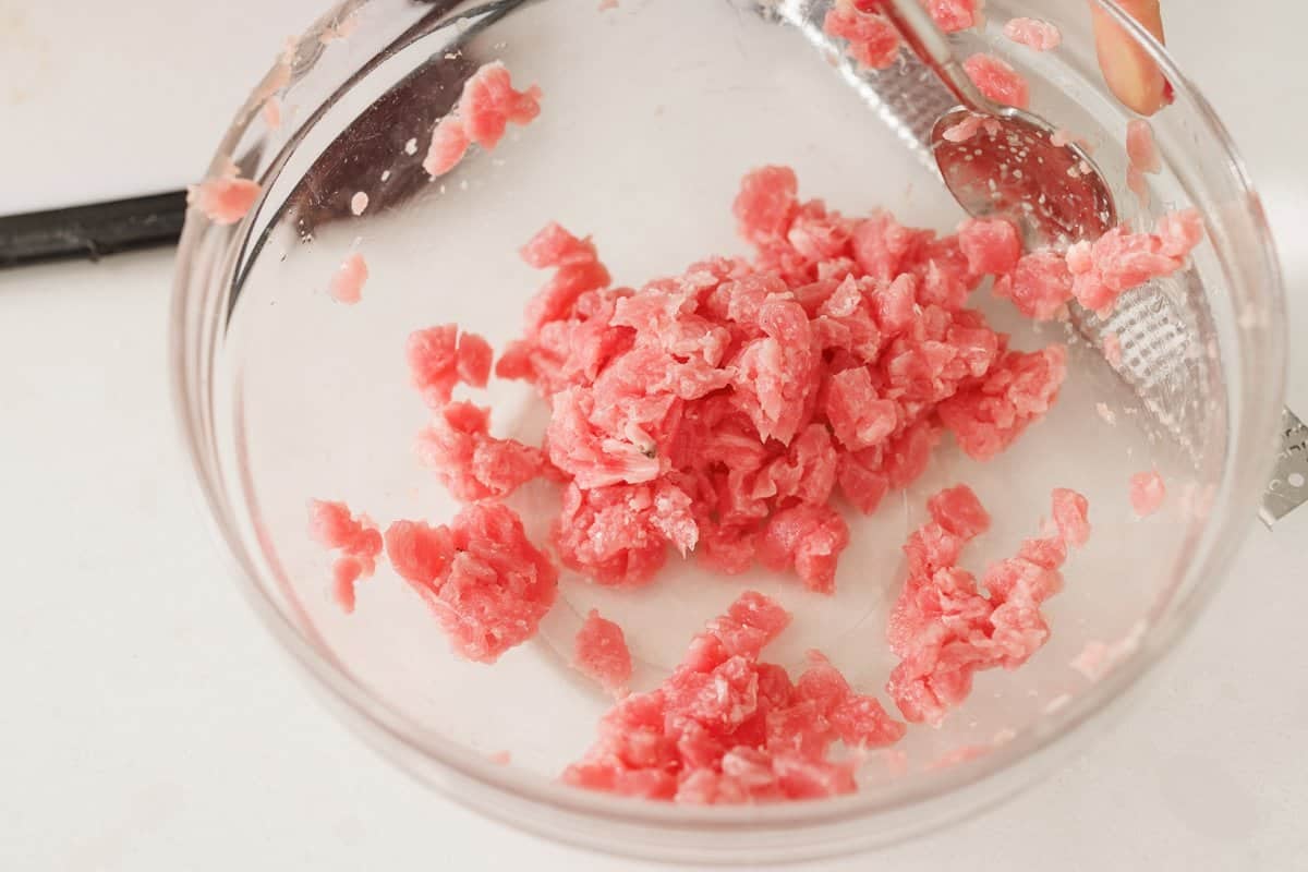 Adding cut ahi tuna steak to a large bowl.