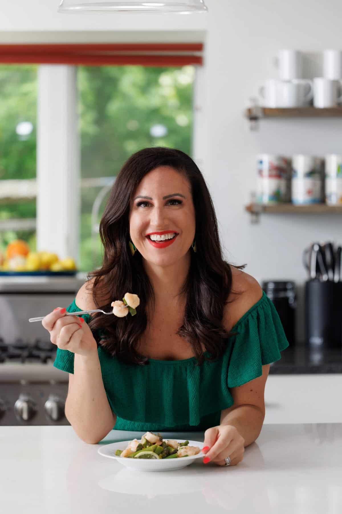 Liz eating shrimp and asparagus pouches with lemon garlic butter.