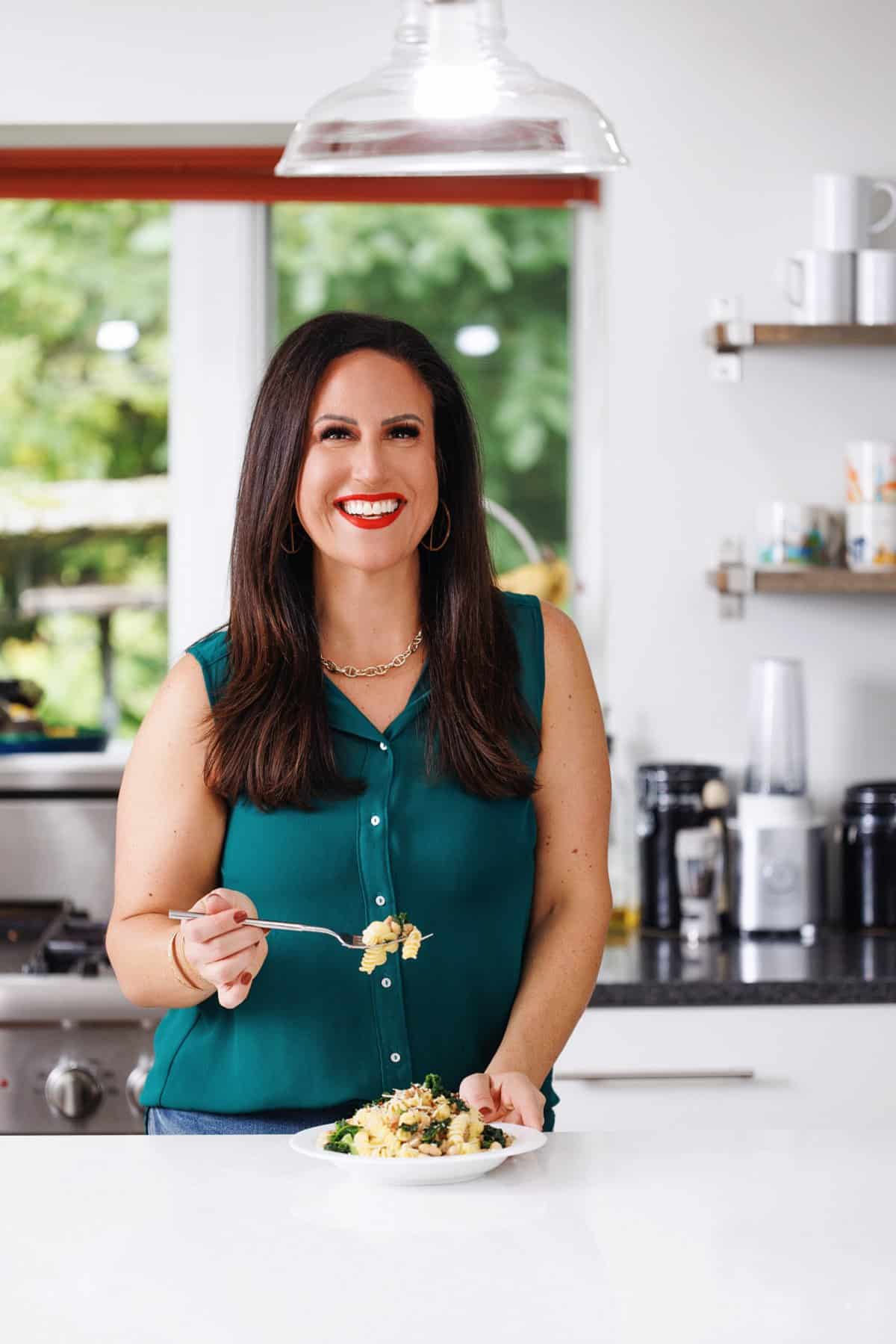 Liz eating sausage and kale pasta with white beans.
