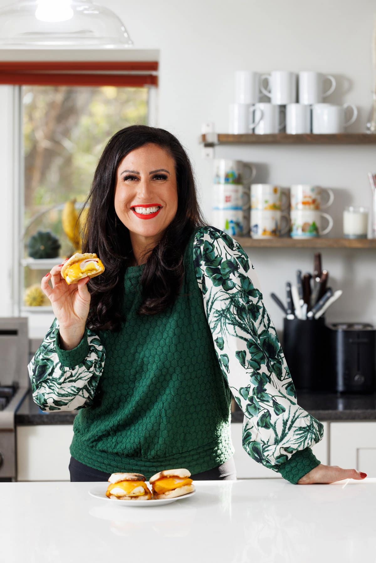 Liz eating an egg, ham, and cheese breakfast sandwich.