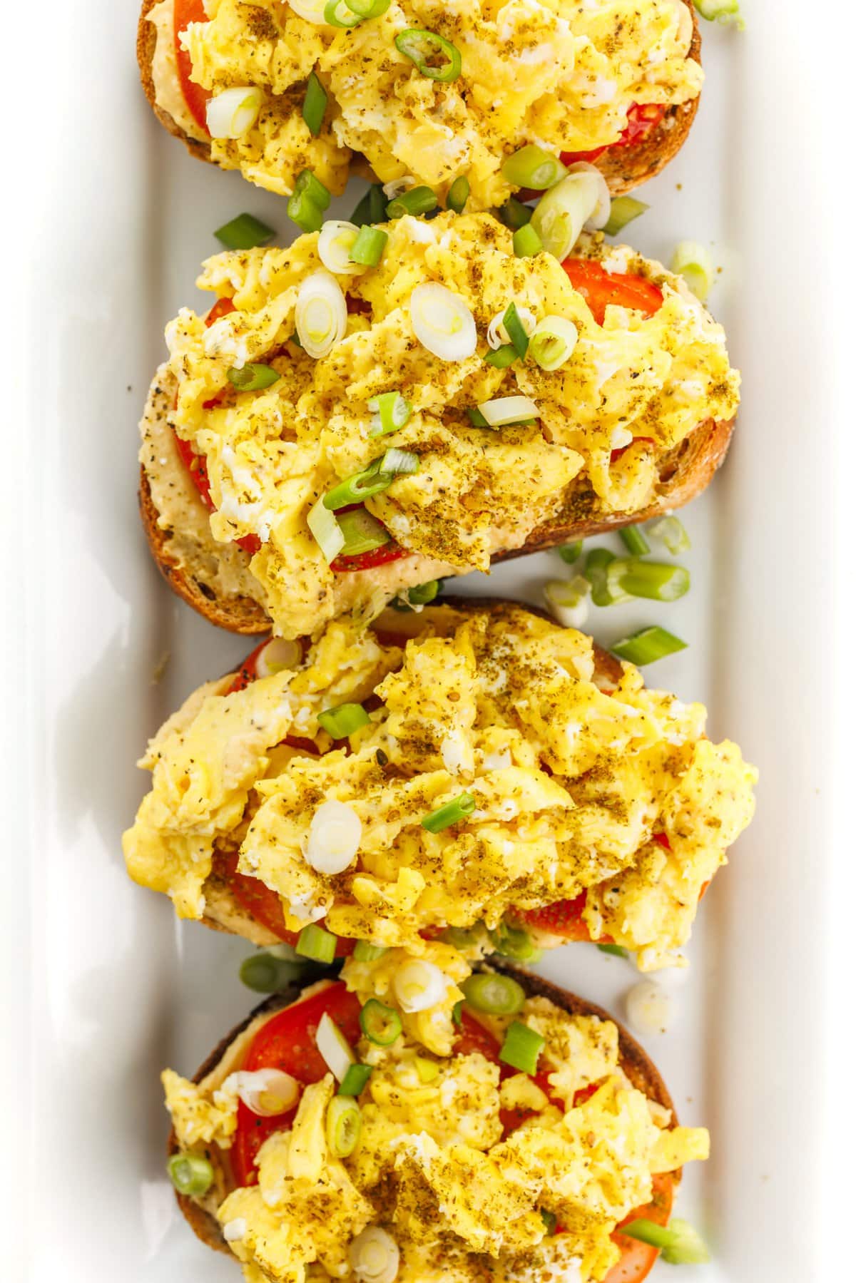 Hummus toast with scrambled eggs top view.