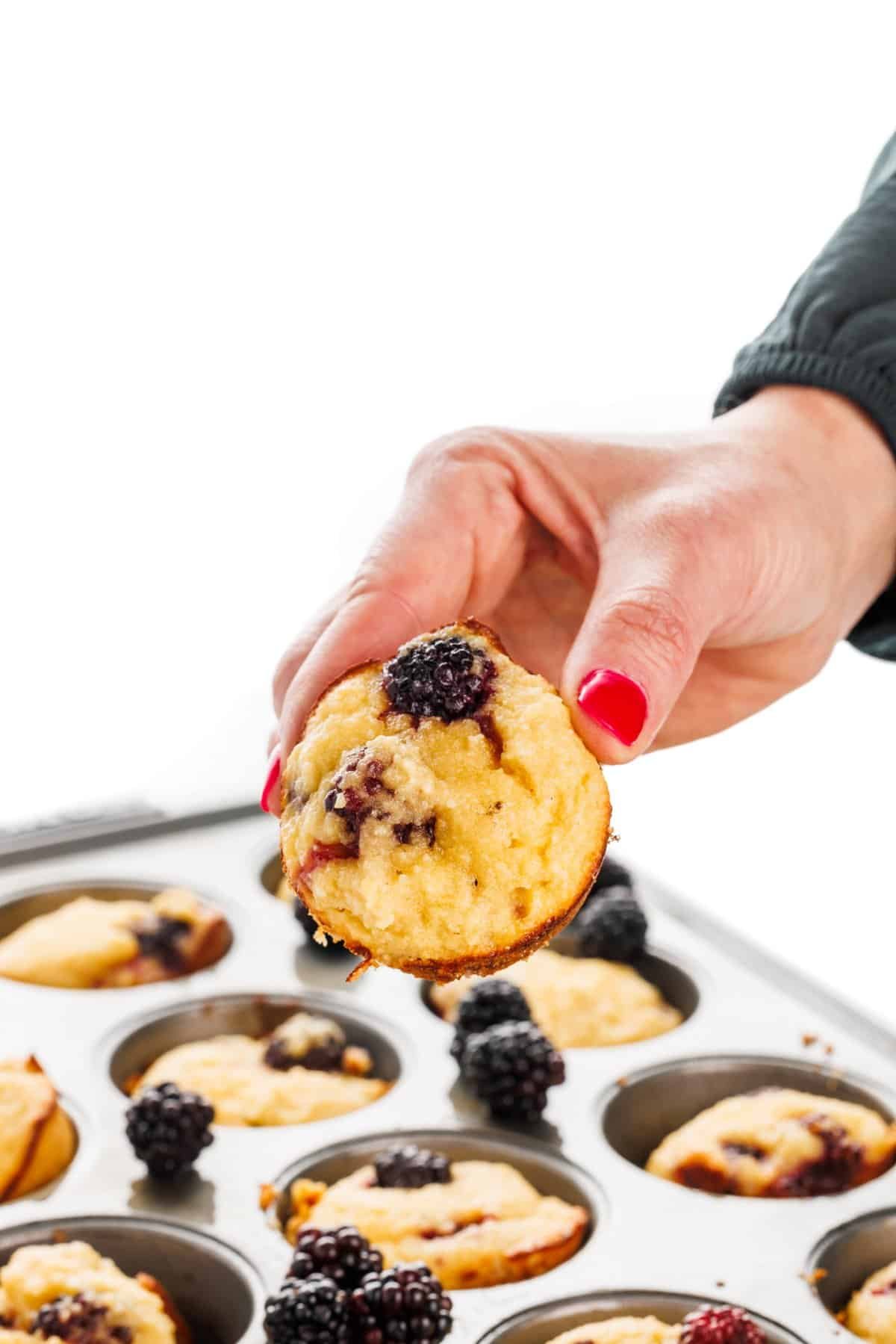 Holding an almond flour blackberry muffin.