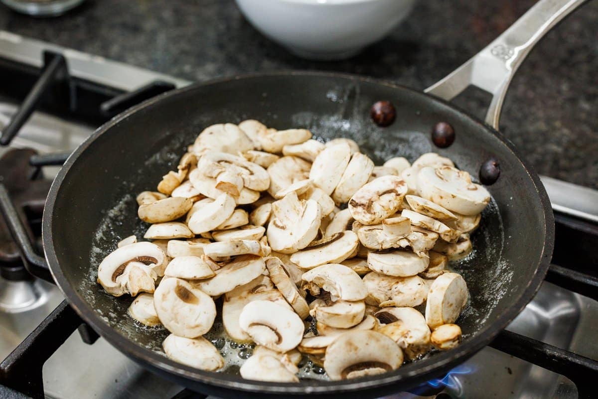 Sauteing mushrooms in butter in a pan.