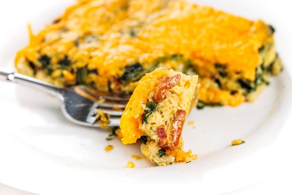 Forkful of bacon and spinach egg casserole.