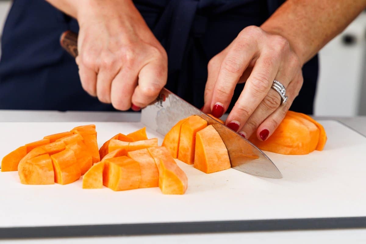 Liz cutting sweet potatoes into small cubes.