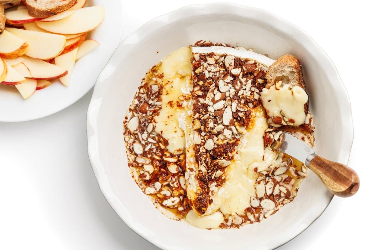 Baked brie with a knife, bread, and apples as one of many healthy appetizer recipes.