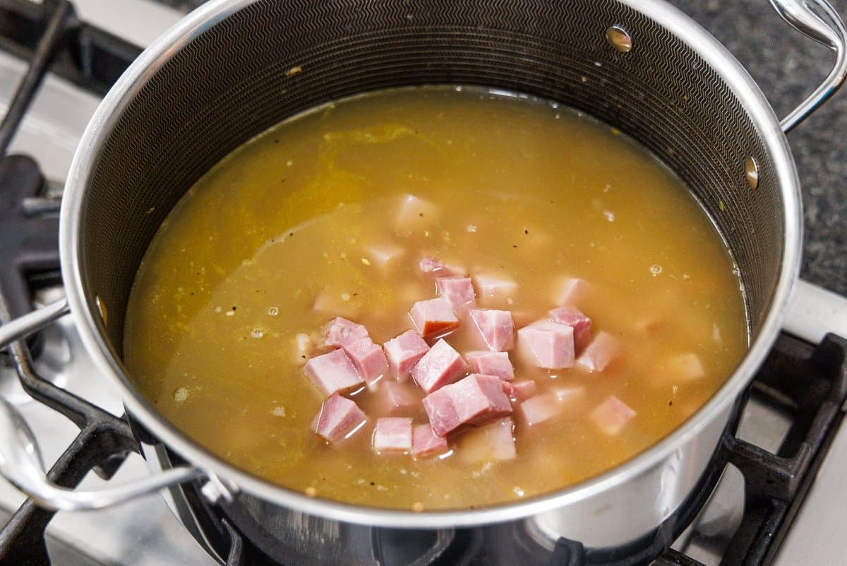 Ham and chicken broth added to a large soup pot.