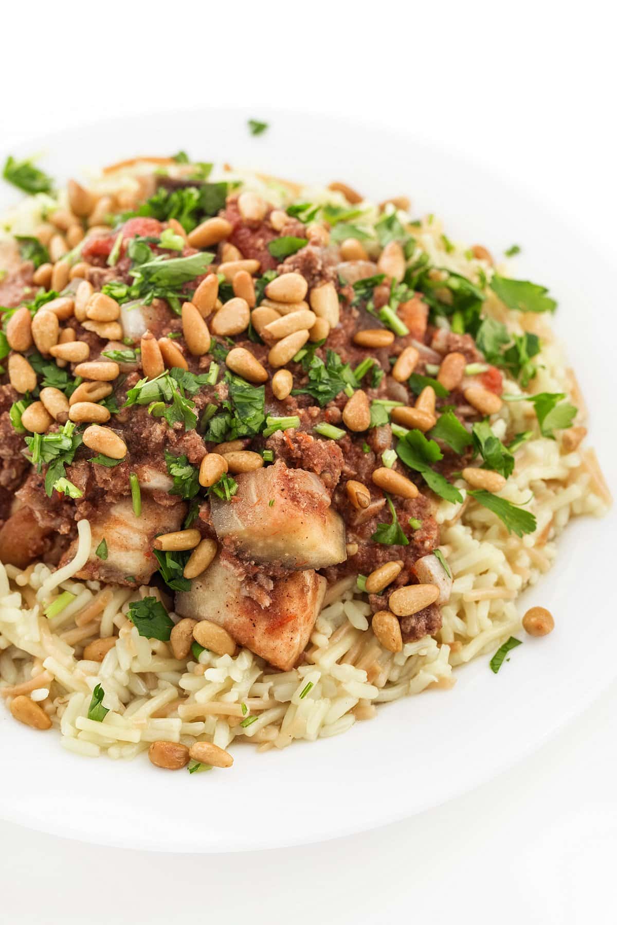 5-ingredient slow cooker beef and eggplant over rice pilaf on a white plate.