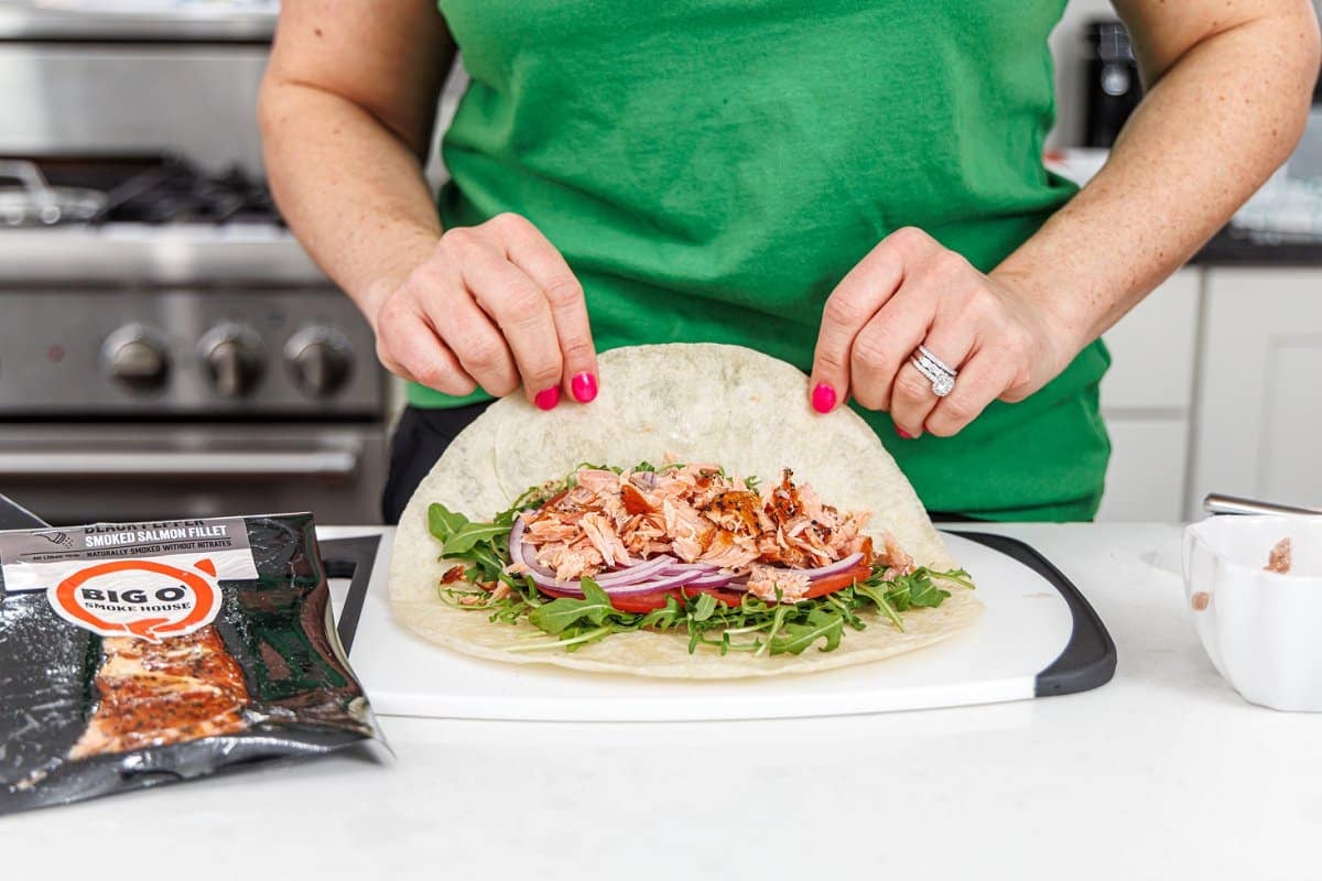 Liz using smoked salmon in a wrap with tomato and arugula.