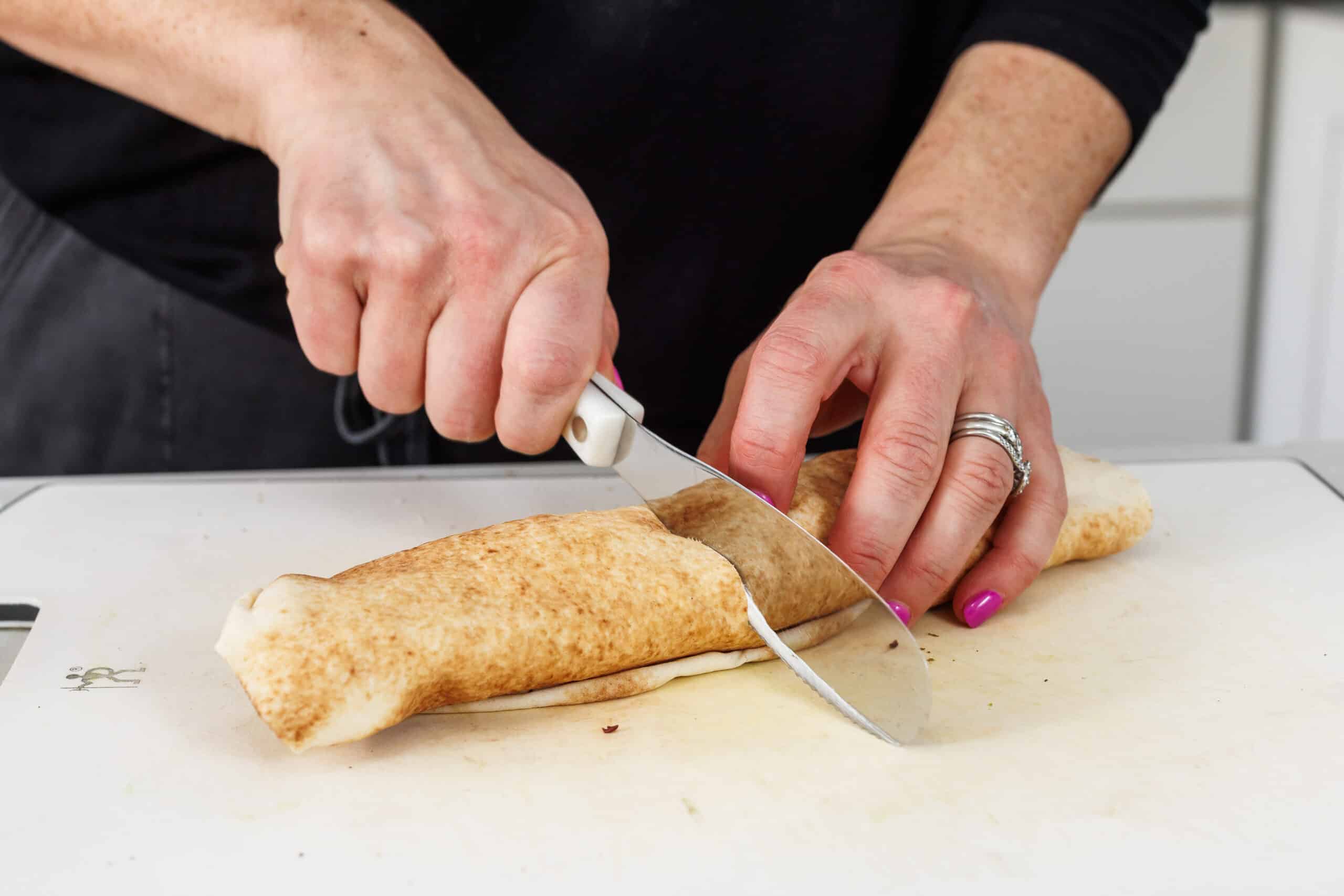Liz cutting Lebanese breakfast pita in half.