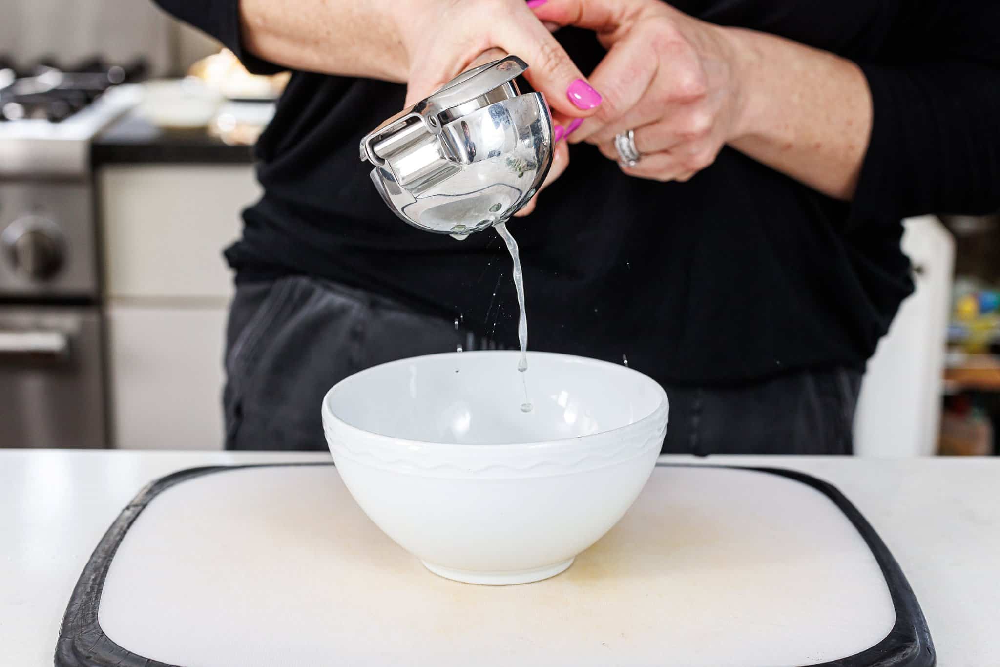 Juicing lime into bowl.
