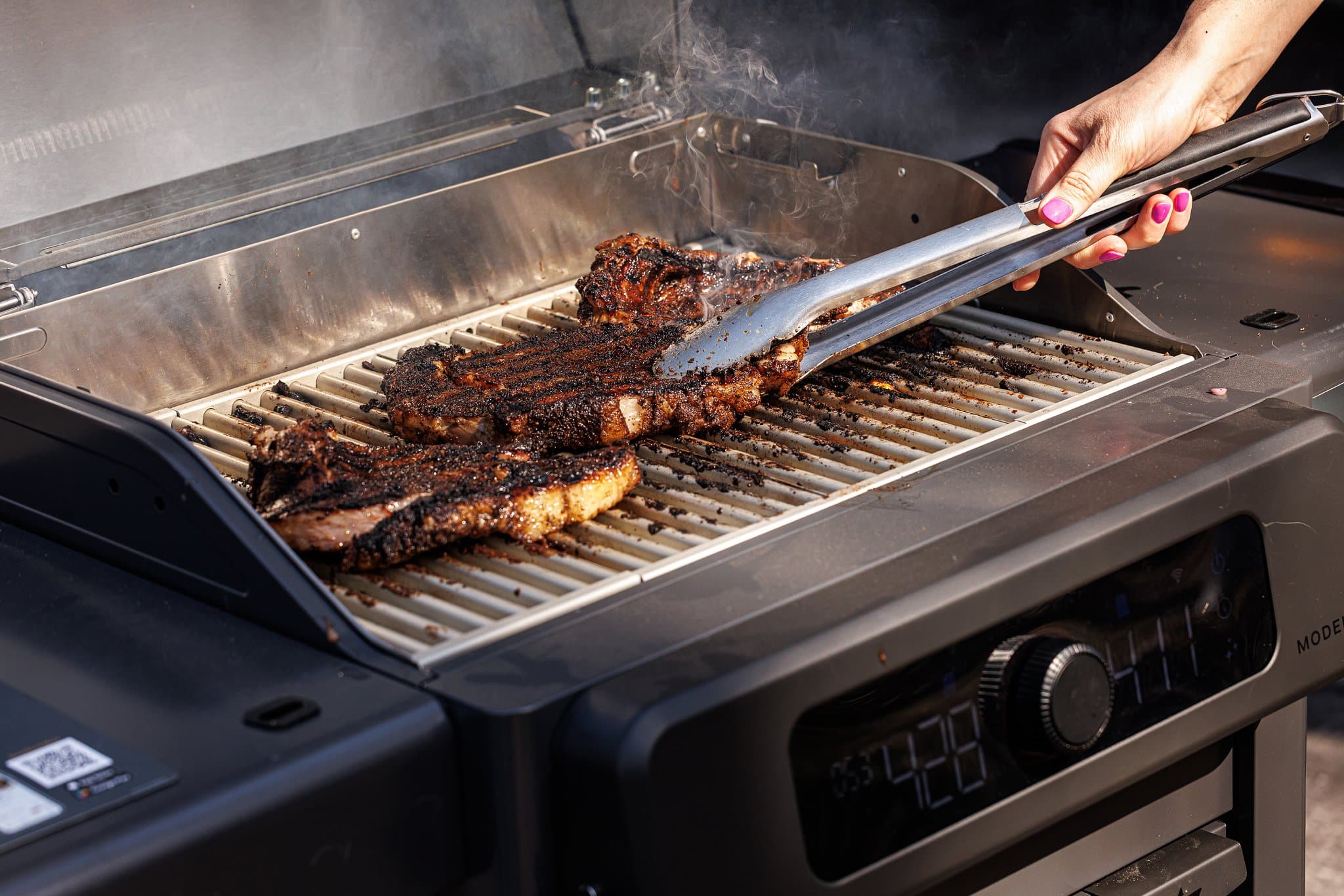 Grilling coffee crusted ribeyes on an outdoor grill.