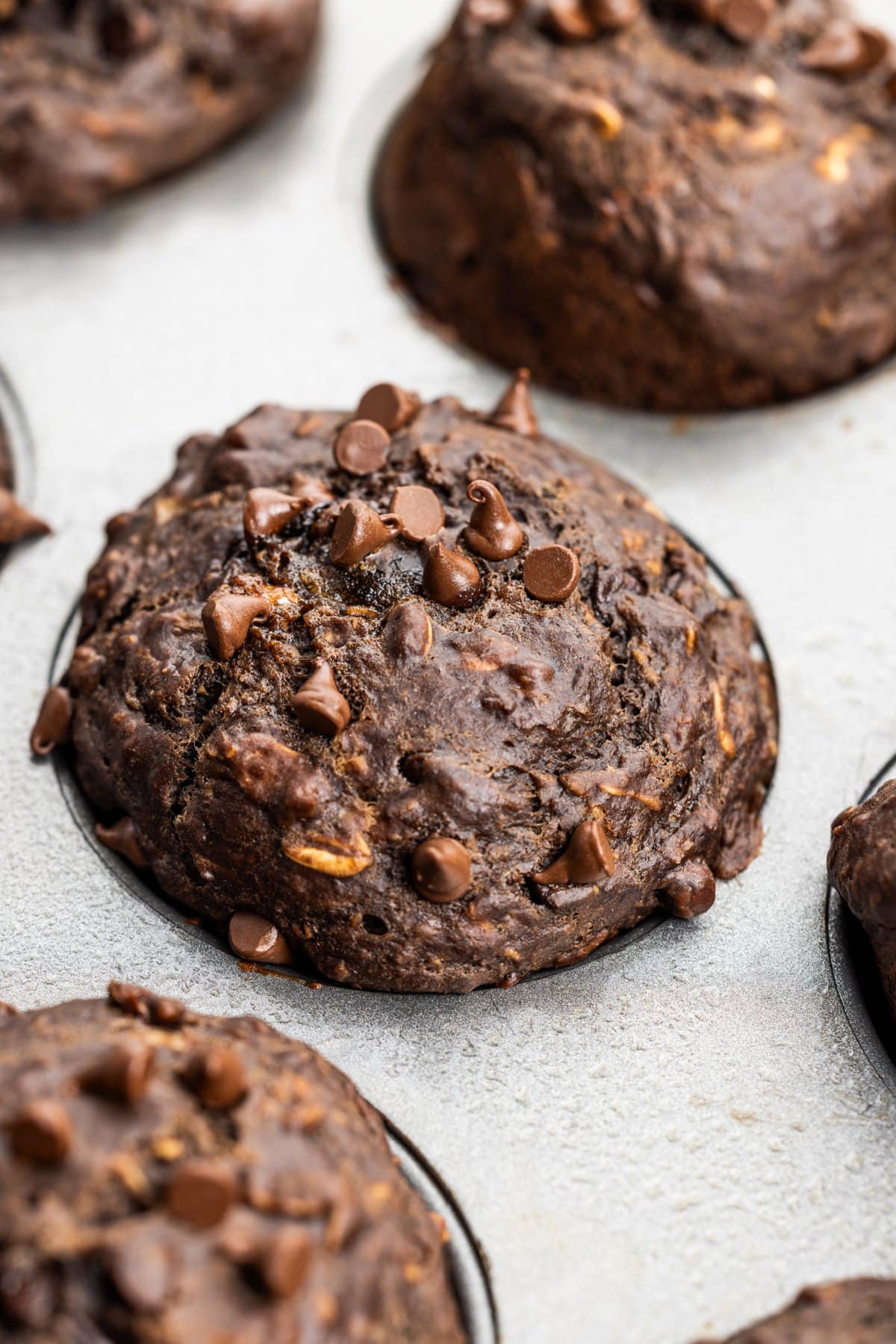 Chocolate banana oat muffin topped with mini chocolate chips.