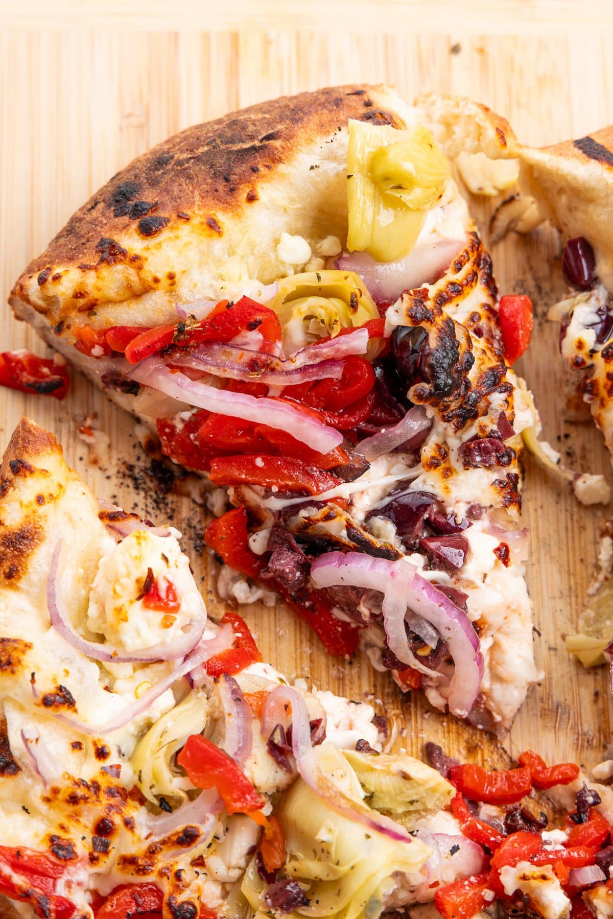 Close up view of a slice of Mediterranean Veggie Pizza.