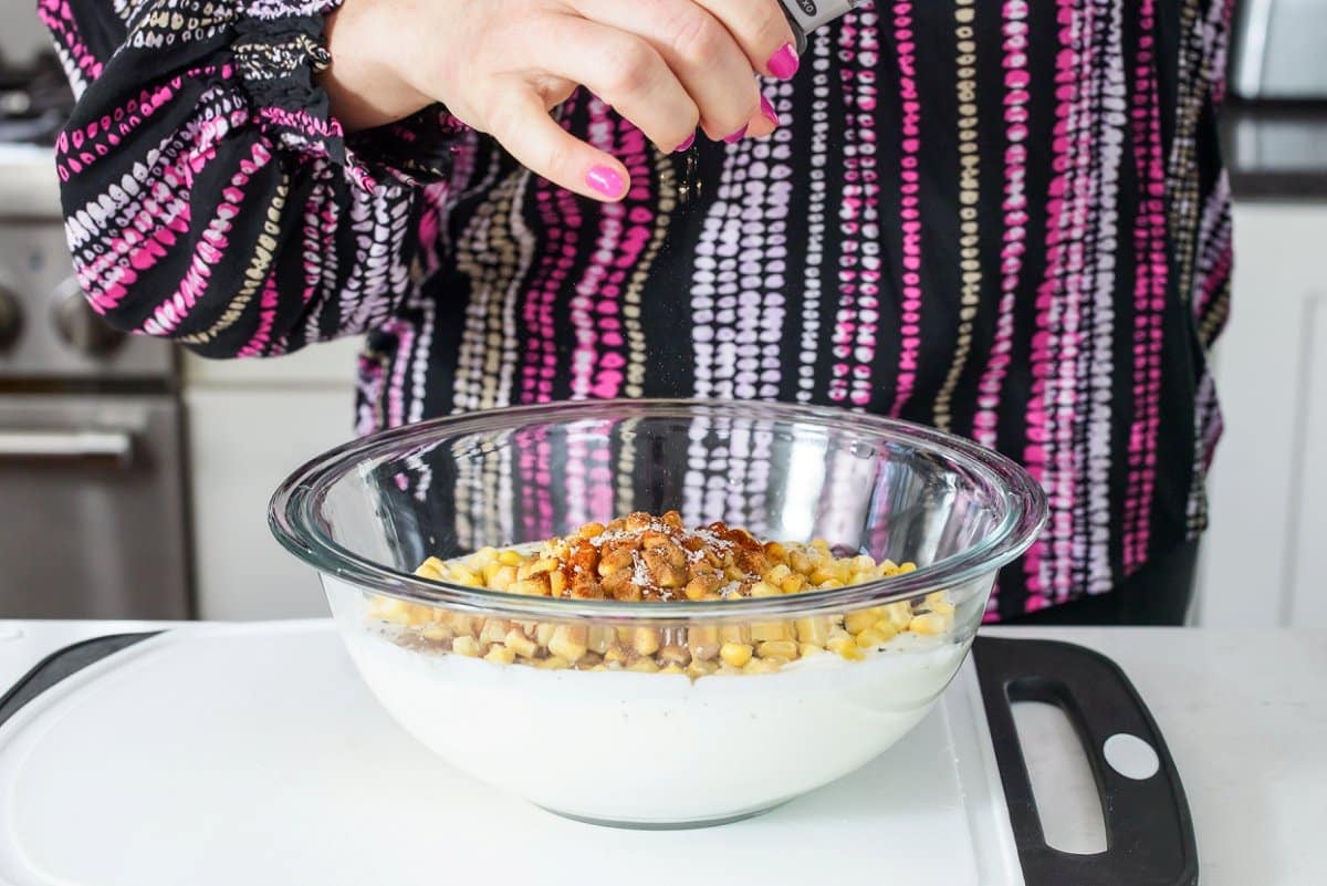 Liz adding pepper to lasagna filling.