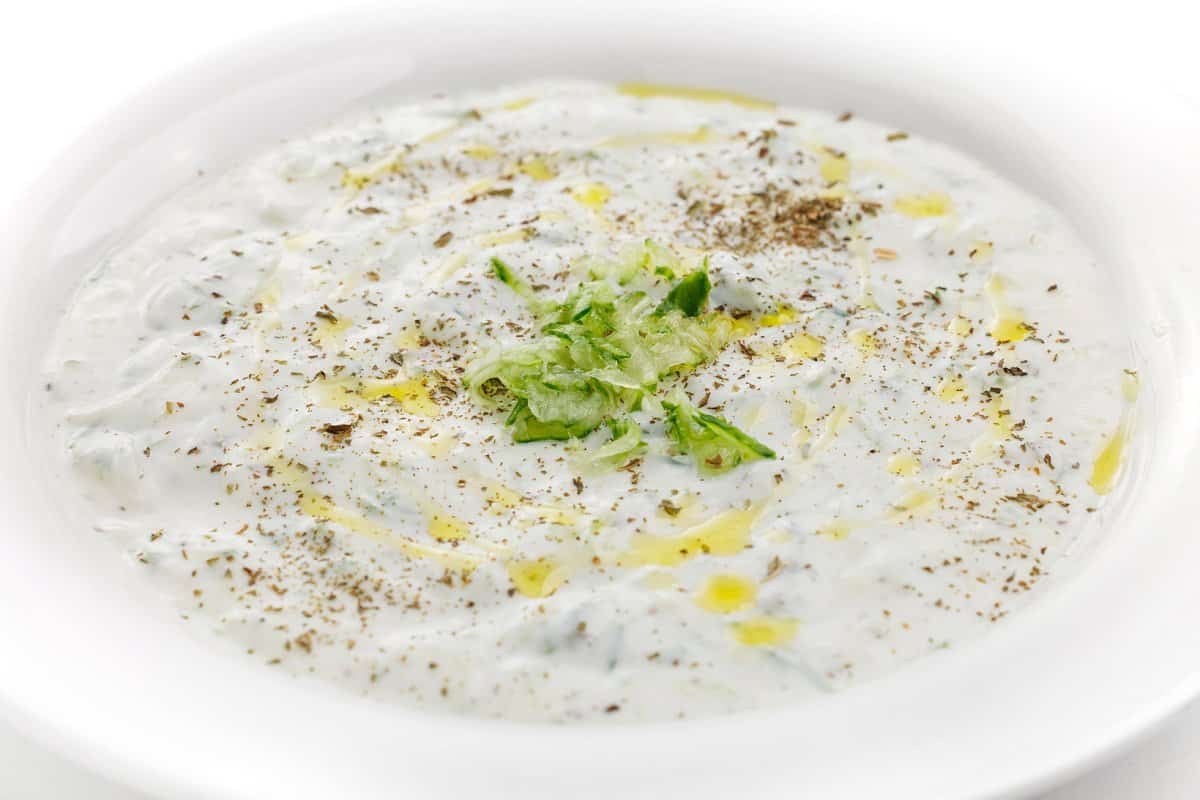 Chilled cucumber yogurt soup in a shallow white bowl.