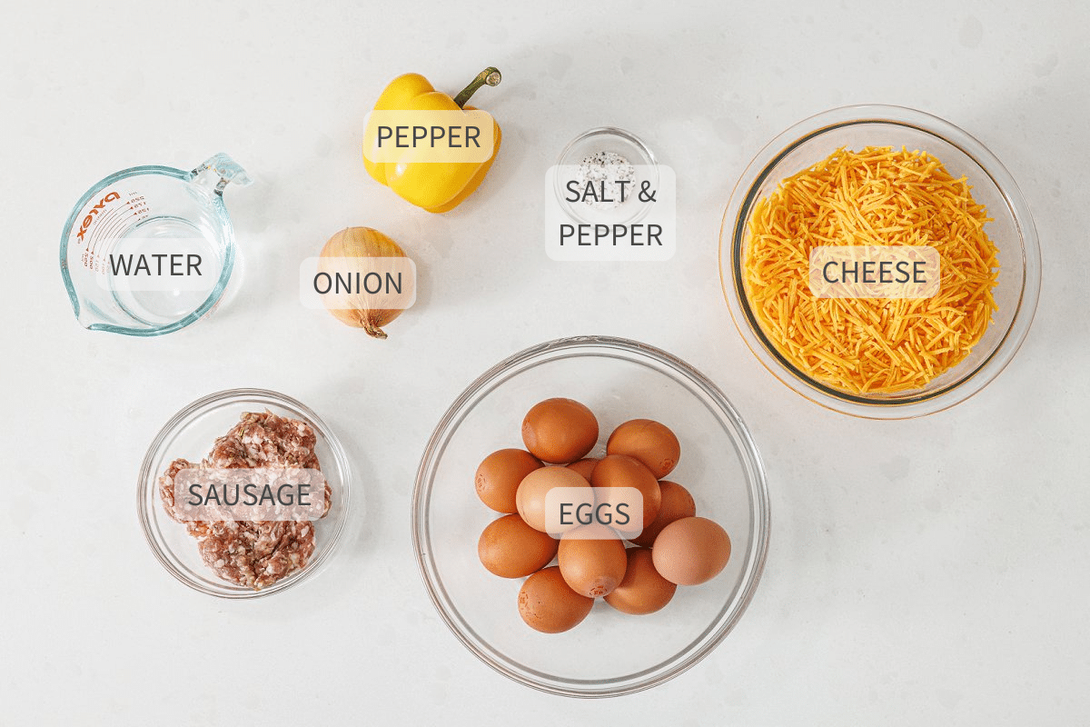 Labeled ingredients for cheesy sausage and pepper egg bake on a white counter.